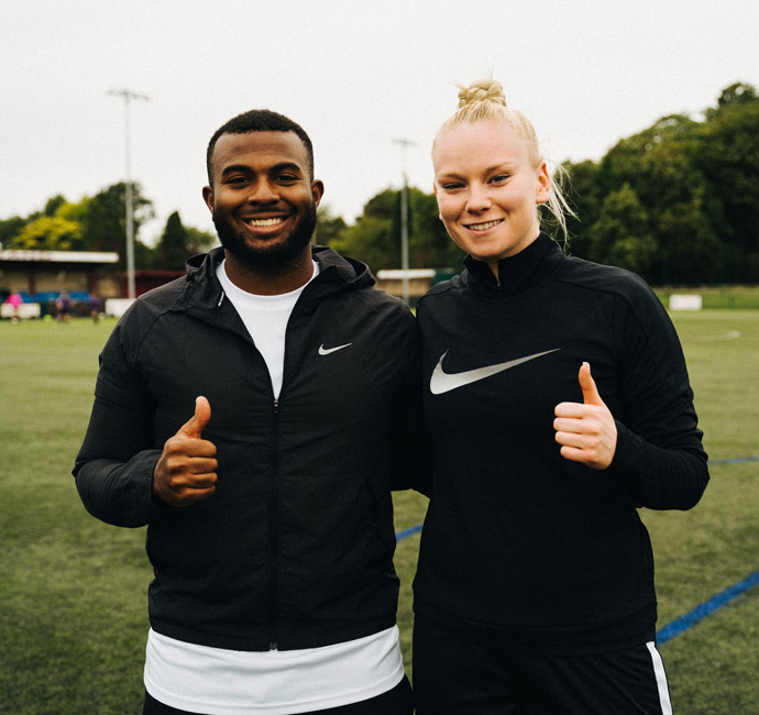 Kray Foster, football coach, on pitch, thumbs up with female client